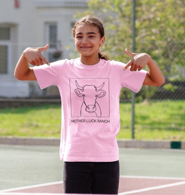 girl wearing the Cowabunga! shirt showing a cow sketch with text "Mother Luck Ranch" in pink