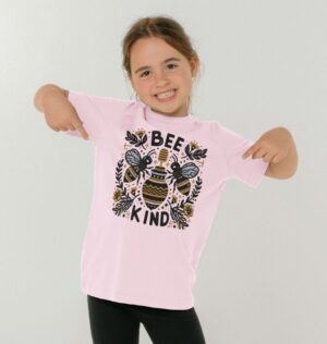 girl wearing pink Bee Kind tee with image of bees, flowers, and honey pot in folk art inspired deign