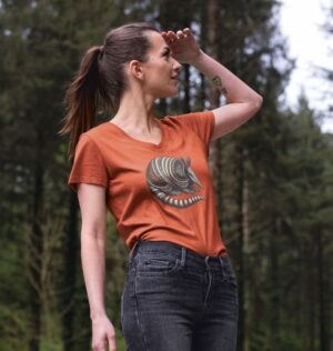 Woman in woods wearing the Women's Banded Armadillo Organic Cotton V-Neck Tee in Rust