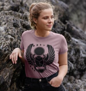 Women by beach rocks wearing the Winged Scarab Organic Cotton Crew Neck Tee in Mauve Color