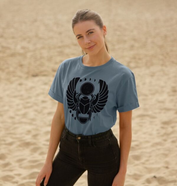 Woman on Beach Wearing Winged Scarab Organic Cotton Relaxed Tee in Stone Blue Color