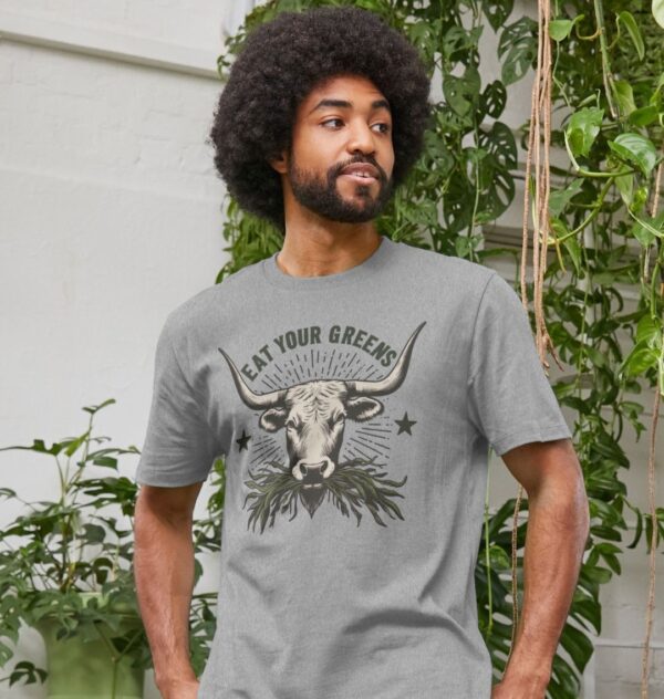 Man wearing the Men's Eat Your Greens Organic Cotton T-Shirt in Athletic Grey Color showcasing a steer eating greens