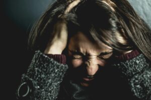 a girl under a lot of stress with hands in her hair