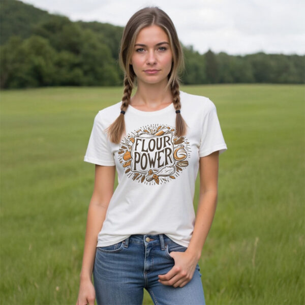 woman with braids wearing white t-shirt with "Flour Power" graphic