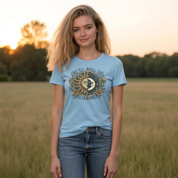 woman wearing the sky blue scoop neck tee with the "Le Soleil La Luna" sun and moon graphic